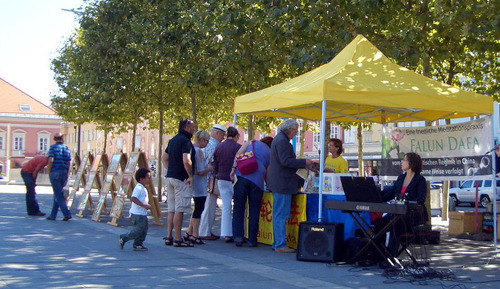 Passanten informieren sich über Falun Gong und unterschreiben die aufgelegten Petitionen