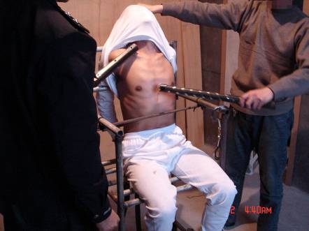Folterdarstellung: An einen Eisenstuhl gefesselt mit elektrischen Schlagstöcken geschockt