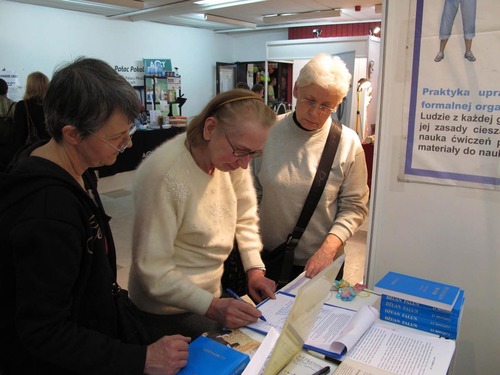 Messebesucher unterschreiben eine Petition gegen die Verfolgung von Falun Gong.
