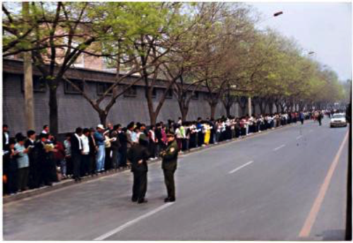 Falun-Dafa-Praktizierende warten am 25. April 1999 in Peking an von den Sicherheitskräften zugewiesenen Stellen.