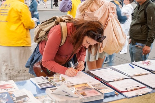 Passanten unterschreiben eine Petition für ein Ende der Verfolgung von Falun Dafa in China. © FDI