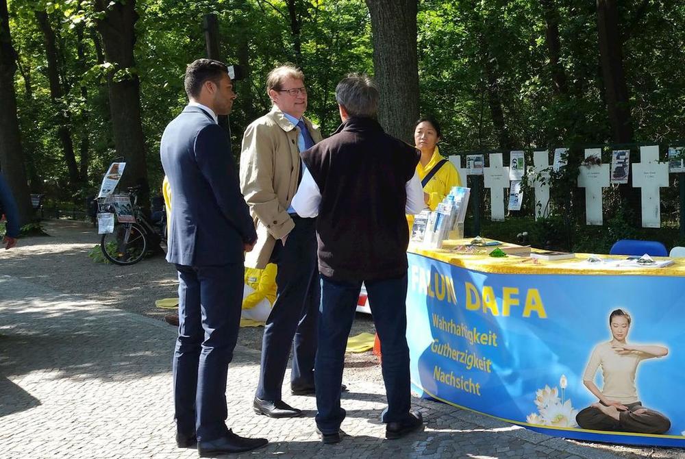 Ein Bundestagsabgeordneter (2.v.l.) informiert sich über die Verfolgung von Falun Dafa in China.
