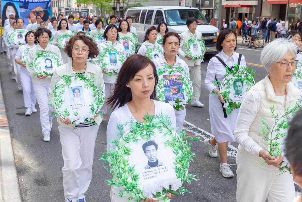 Praktizierende tragen Fotos der Falun-Dafa-Praktizierenden, die infolge der Verfolgung in China ums Leben gekommen sind.