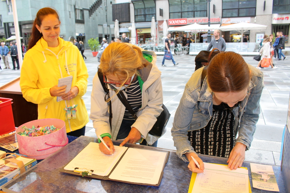 Passanten unterschreiben die Petition gegen den Organraub. © FDI Österreich