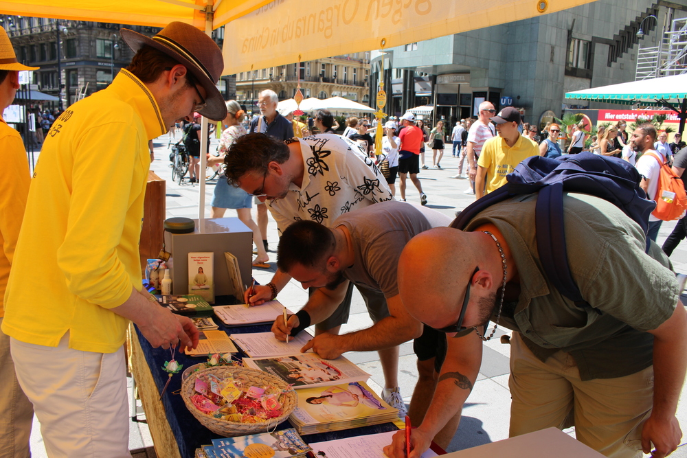 Passanten unterzeichnen die Petition gegen den Organraub an Falun-Gong-Praktizierenden in China. Foto: FDI Österreich 