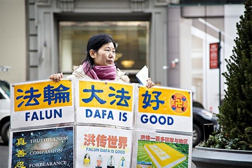 Wang Huijuan, vor dem Empire State Building in Manhattan in New York, am 12. Jänner 2017, hält ein Plakat im den Händen, um den chinesischen Touristen zu helfen, die Wahrheit über die Verfolgung von Falun Gong in China zu verstehen. (Samira Bouaou / Epoch Times)