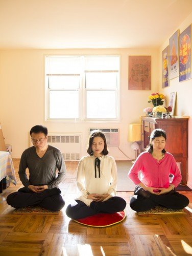 Li Zhenjun, Li Fuyao und Wang meditieren in ihrem Haus in Queens, New York. (Samira Bouaou / Epoch Times)