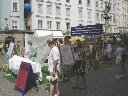 Auf dem von Touristen stark frequentierten Alten Markt in Salzburg bleiben Menschen interessiert stehen, informieren sich über die Verfolgung in China und beobachten die nachgestellten Organentnahmen.