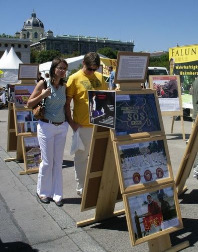 Passanten informieren sich anhand von Schautafeln über die Verfolgung an Falun Gong in China