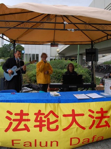 Mit Liedern über die Schönheit, aber auch die brutale Verfolgung von Falun Gong, ziehen Praktizierende Passanten vor der UNO an